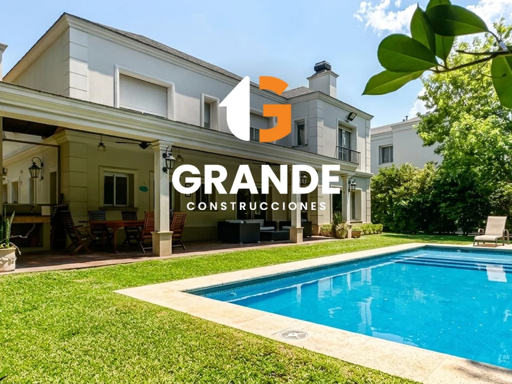Casa con jardín y pileta construida por Grande Construcciones, con el logo de la empresa